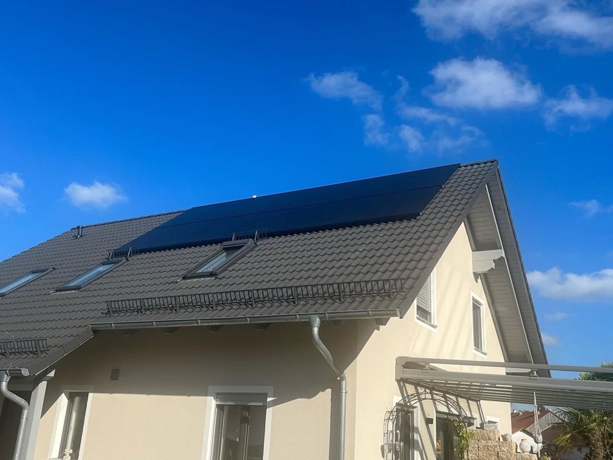 Dunkle Solarpaneele auf dem grauen Ziegeldach eines Hauses