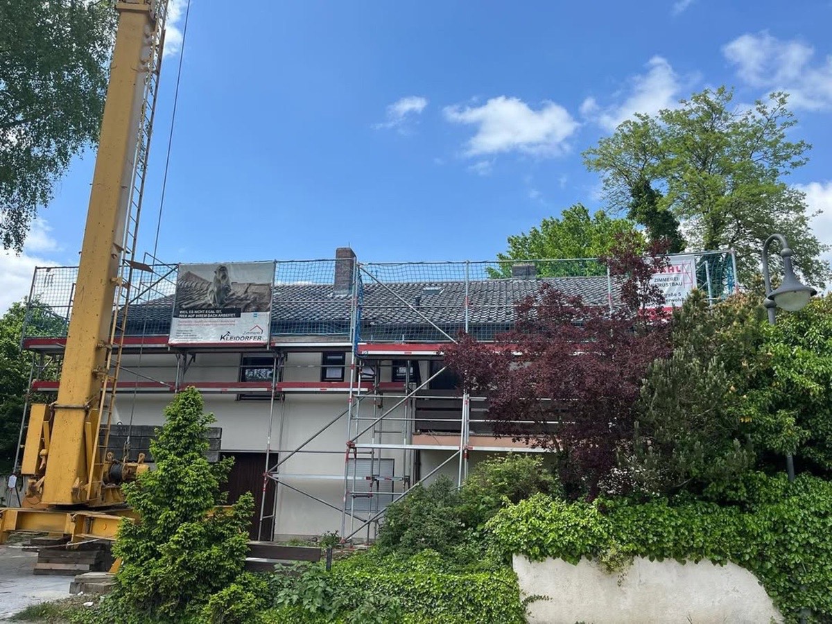 Ein Haus mit Gerüst und einem großen gelben Kran